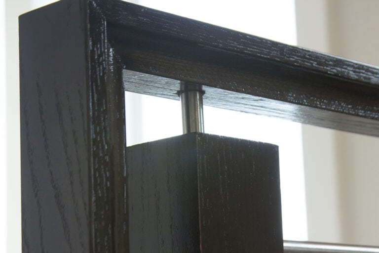 Round bar stem handrail bracket on a horizontal bar stair railing