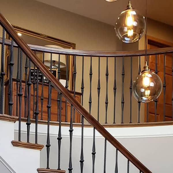 Gothic Hammered iron balusters on a curved balcony railing with pendant lights