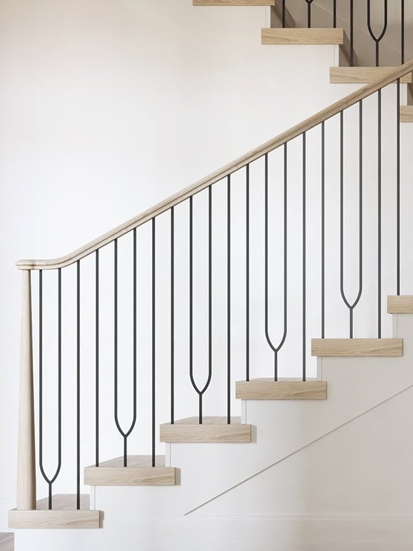 Harmony iron balusters with an elongated loop design on light oak stairs
