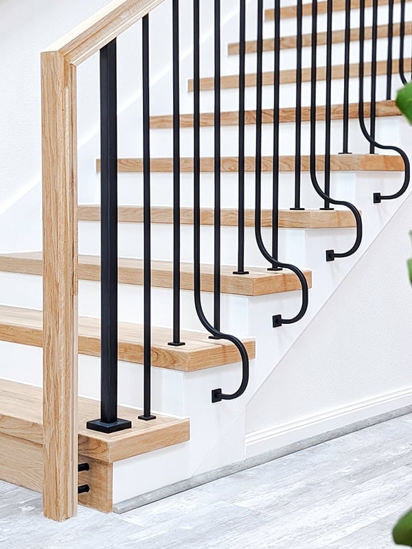 Heights side-mount iron balusters curving onto the side of oak stair treads