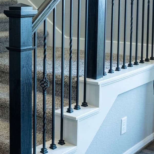 MEGA 3/4-inch square iron balusters with twist and basket accents beside a black newel