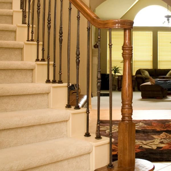 Monte Carlo iron balusters with an oil-rubbed bronze look on a carpeted staircase
