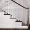 Röhe pin top newel post on a staircase with a dark handrail