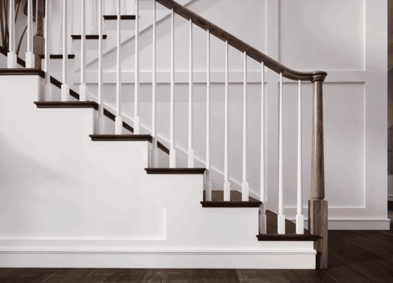 Röhe pin top newel post on a staircase with a dark handrail