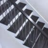 Staircase with 48-60 in retrofit return tread kit with riser, red oak