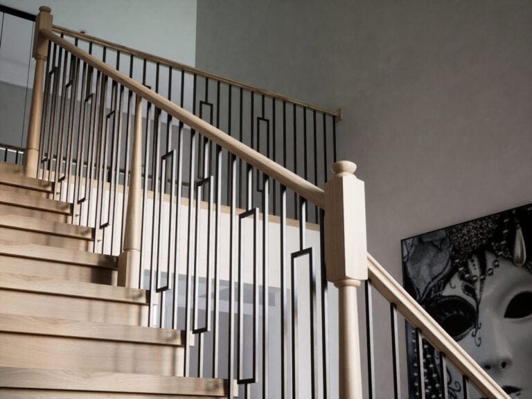 Staircase with a Röhe stabilizer newel post and iron balusters