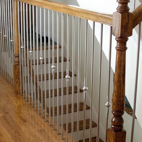 Stainless steel balusters with knuckle accents on an oak staircase