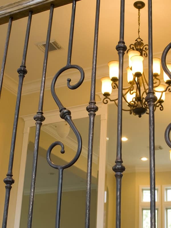 Tuscan Round hand-hammered iron balusters with knuckles and a scroll baluster