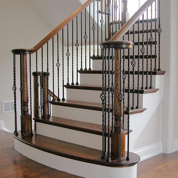 Twist and Basket hollow iron balusters on a curved bullnose staircase
