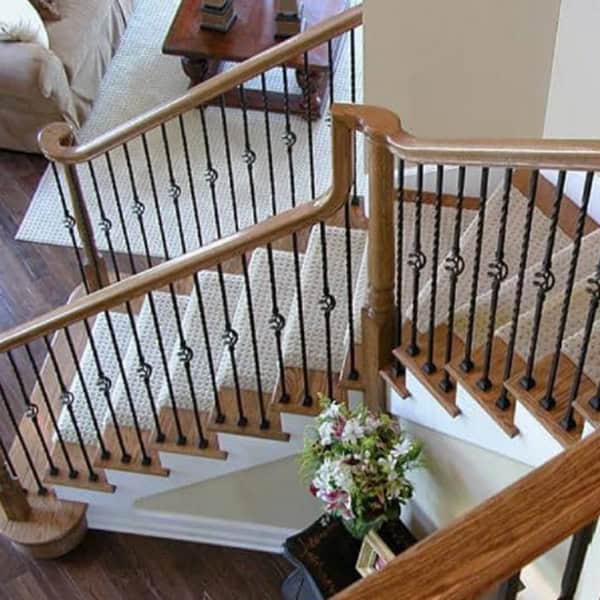 Twist and Basket solid iron balusters on an L-shaped staircase with oak handrails