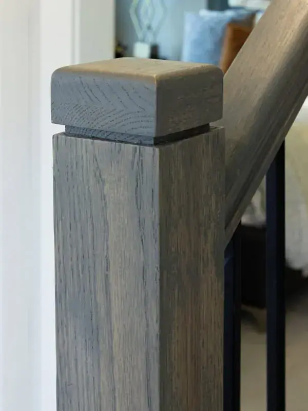 Wood newel posts with an oak handrail on a staircase